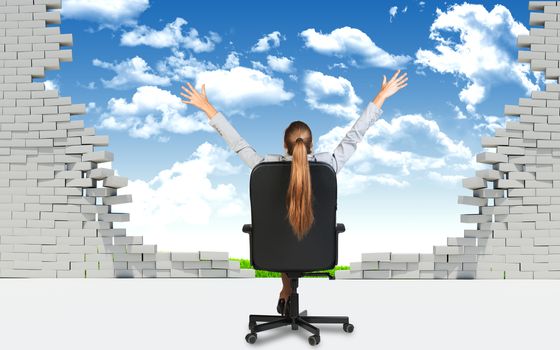 Businesswoman sitting on the office chair with her hands outstretched, in front of broken wall with blus sky and green field behind it.