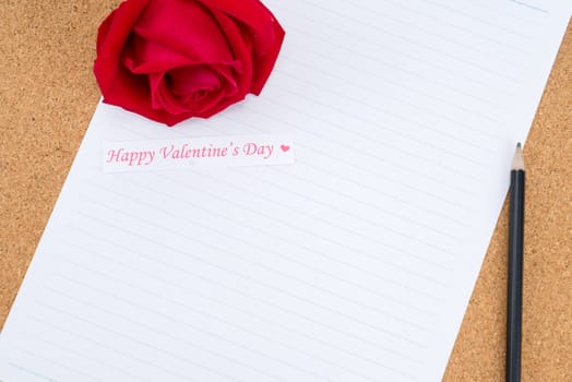 Cardboard, corkboard with note paper with pencil and rose beside for romantic planning, space for text