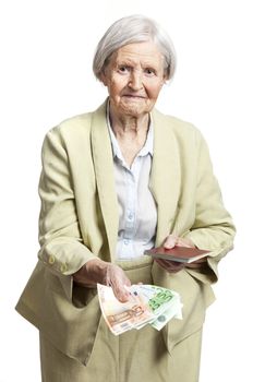 Senior woman giving money and holding passport, face in focus. Isolated over white.