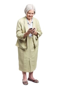 Senior woman using mobile phone while standing over white background