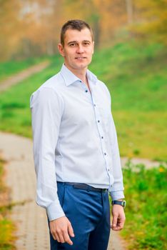 handsome man in shirt and trousers smiling