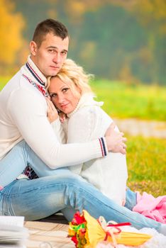 portrait of a loving couple hugging sitting in the park