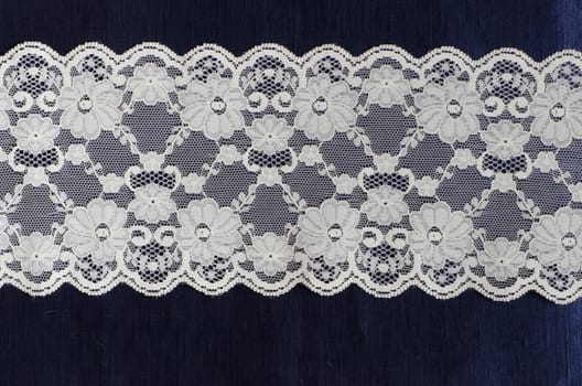 floral lace on the blue silk satin fabric