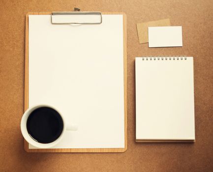 Blank white paper on clipboard and notebook with cup of coffee, retro filter effect