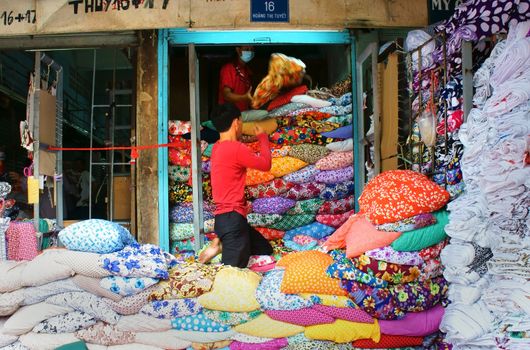 HO CHI MINH CITY, VIET NAM- DEC 28: Asia fabric market, colorful roll of cloth for clothing show at store, Vietnamese worker working at shop, garment industry develop to export, Vietnam, Dec28, 2014