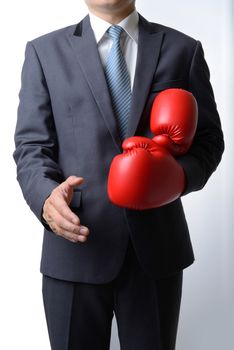 Businessman take off red boxing gloves to offer a handshake on white background,compromise concept