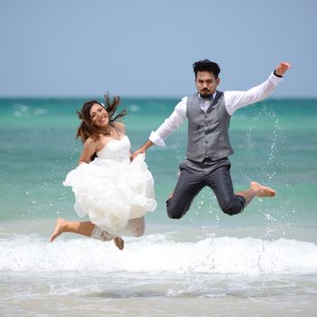 happy just married young couple celebrating and have fun at beautiful beach