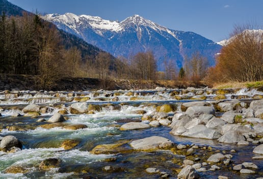 landscape with mountains trees and rocky river. Pinzolo, Italy, Alps

