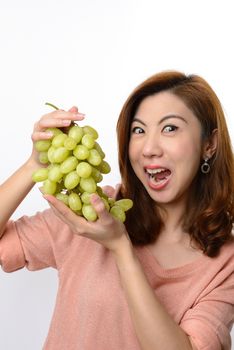 Beautiful asian woman shocked expression while holding green grape