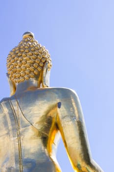 close-up back view big Buddha statue in thailand on blue sky background, copyspace on the right