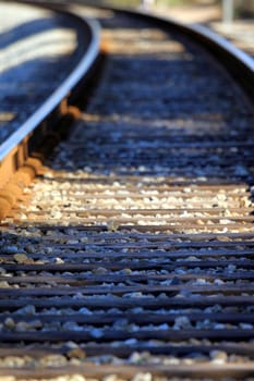 Lower view of train tracks with gravel.