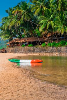 sandy beach in the tropics and canoes by the river