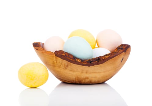 Easter eggs in wooden bowl, isolated on white background