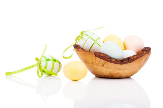 Easter eggs in wooden bowl, isolated on white background