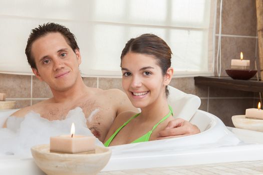 Happy couple in the tub of spa