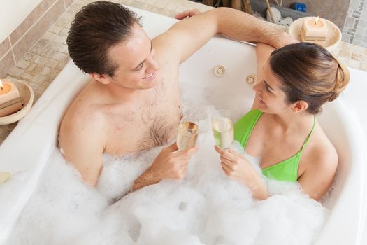 Couple in the tub toasting