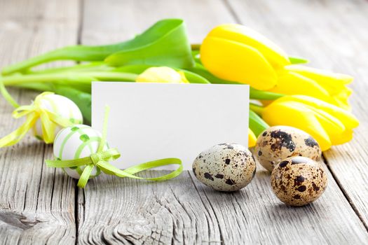 Quail eggs and Easter eggs on wooden background