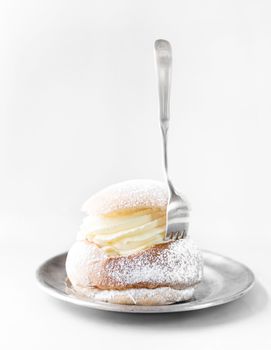 Semla cream bun on silver plate. Pastry typically eaten in Sweden in February.