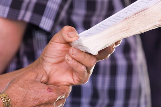 Hand holding book to read while sitting in a car, concept of eye health problem, Very short depth-of-field