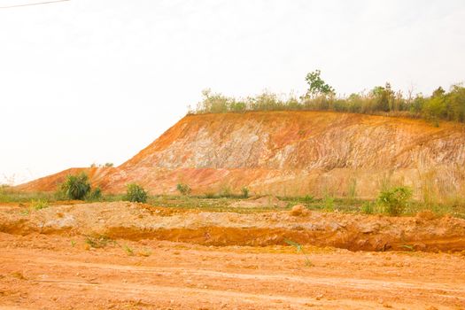 Layer of soil Front loader strips all side of a hill.