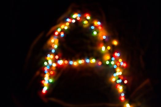 colorful letter A made of blurred circular bokeh on black background