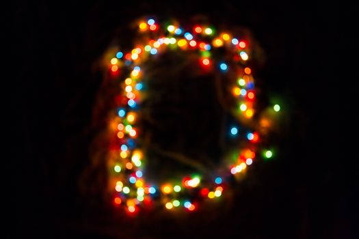 colorful letter D made of blurred circular bokeh on black background