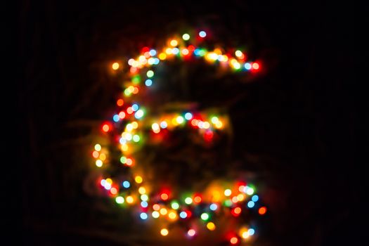 colorful letter E made of blurred circular bokeh on black background