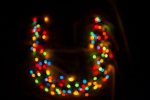 defocused colorful letter U made of blurred circular bokeh on black background