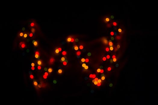 defocused colorful letter W made of blurred circular bokeh on black background