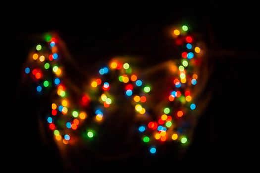 defocused colorful letter W made of blurred circular bokeh on black background