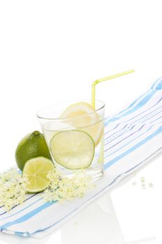 Elderberry lemonade with fresh lemon and lime and elderberry blossom isolated on white background. Fresh summer healthy drink