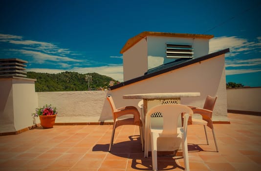 table and chairs on the roof under the open sky on a sunny day