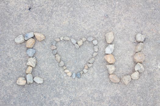 word i love you of stones on concrete background