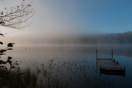 Early morning sunrise burns off the fog which has lingered over the lake.