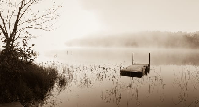 Early morning sunrise burns off the fog which has lingered over the lake.