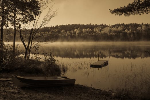 Early morning sunrise burns off the fog which has lingered over the lake.