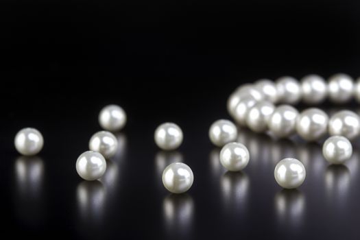 white pearls necklace on black background