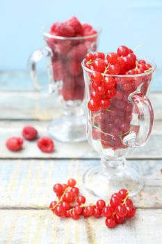 much fresh red currant and rasberry in a transparent cup