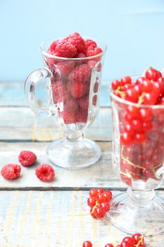 much fresh red currant and rasberry in a transparent cup