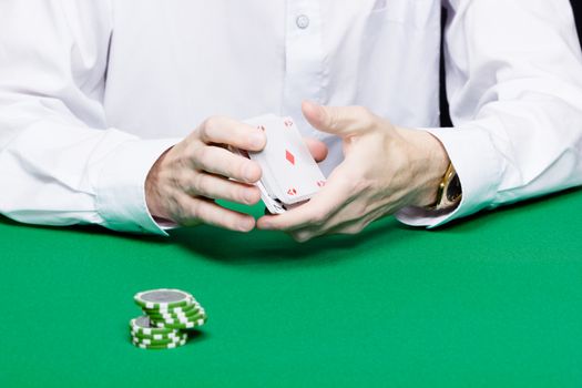 card player. Male hand with cards and chips close-up