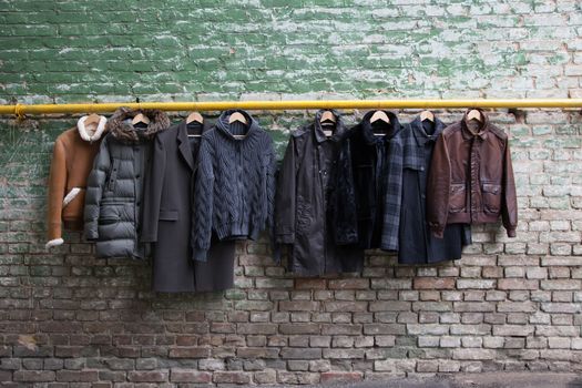 Men's trendy clothing on grunge brick wall. Concept background