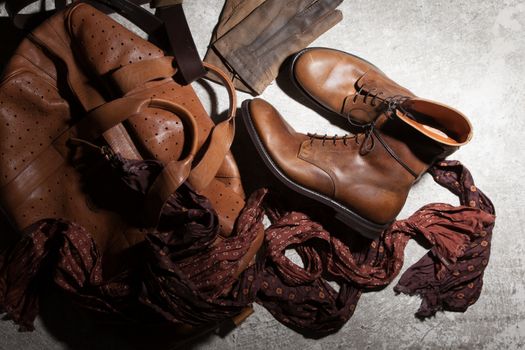 Brown leather bag and accessories on a dark background