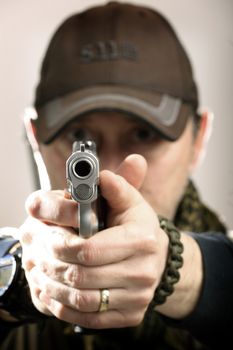 man takes aim with a gun, shallow DOF