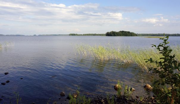 View at the small lake from the high stony shore