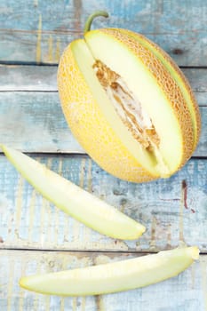 one cut fresh ripe melon on a wooden background
