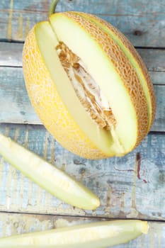 one cut fresh ripe melon on a wooden background