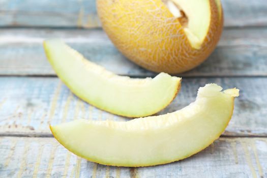 one cut fresh ripe melon on a wooden background