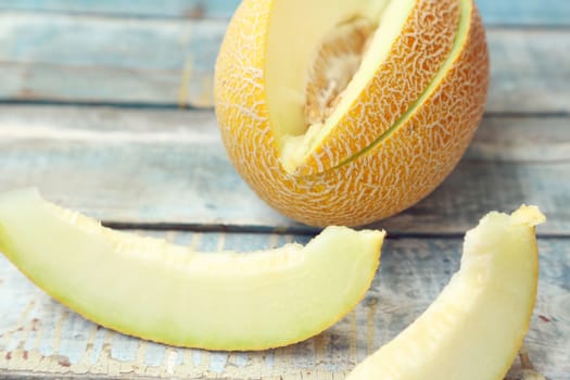 one cut fresh ripe melon on a wooden background