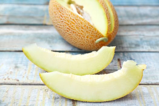 one cut fresh ripe melon on a wooden background