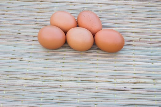 Close up of five eggs on thai traditional mat for cook, with copyspace